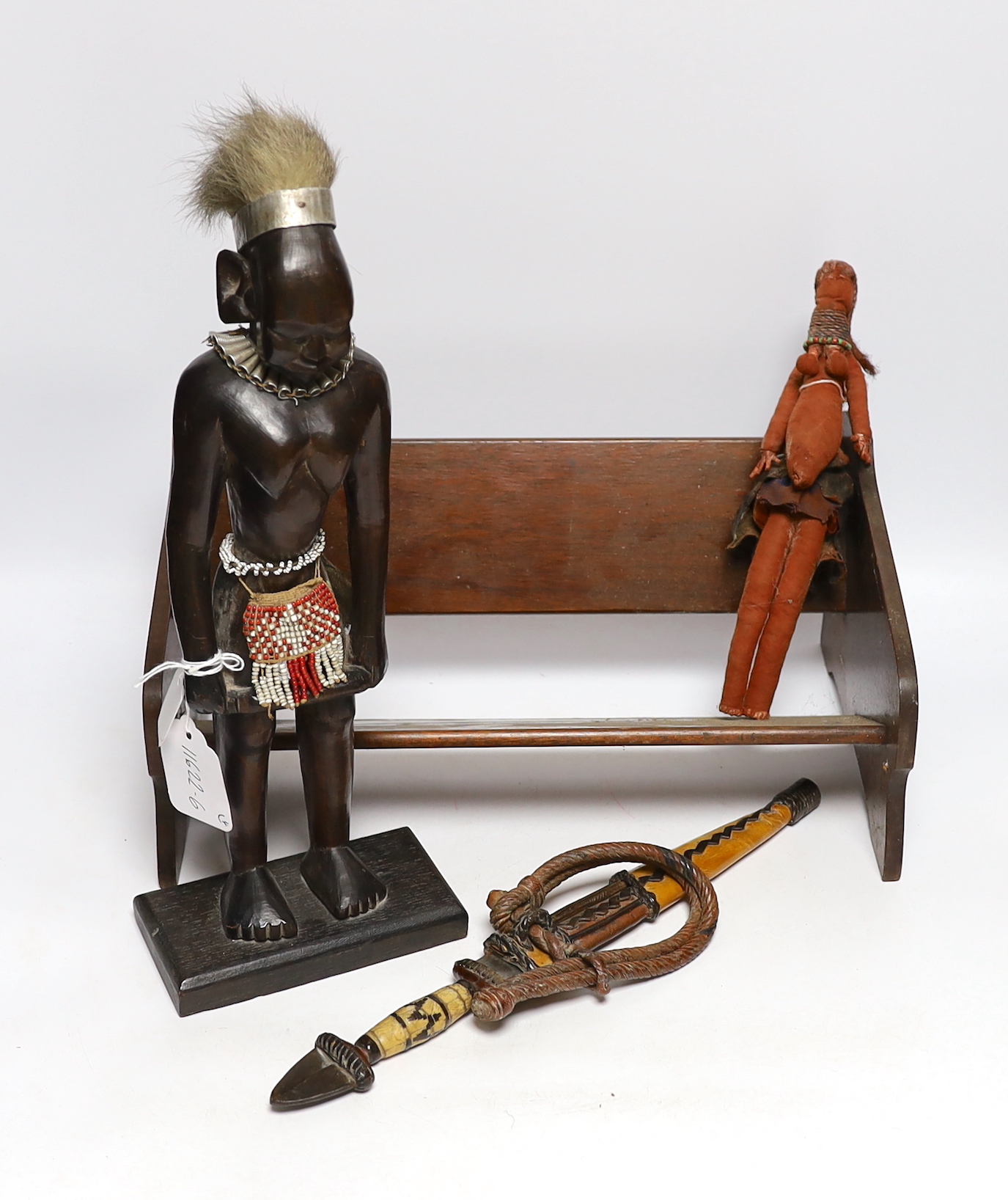 A collection of tribal items including fabric doll, African carved wood figure and dagger, largest 35cm wide